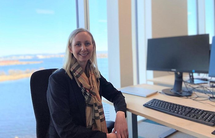 Louise Hulander sitter vid en arbetsplats med utsikt över Munksjön. Hon tittar in i kameran och ler.